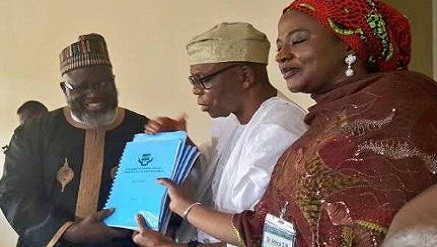 (L-r): Barrister Adebayo Shittu, minister of Communications, receiving report on ICT University presented by Prof Julius Okojie, chairman of the Committee and supported by a member.